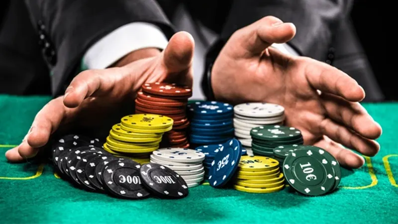 Casino chips being pushed forward in risky all-in betting move on gaming table