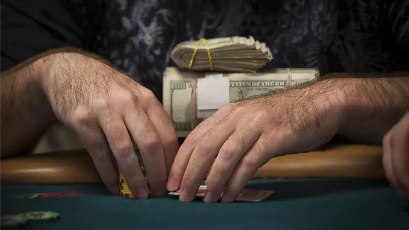 Money stacks divided into separate piles demonstrating proper bankroll management technique