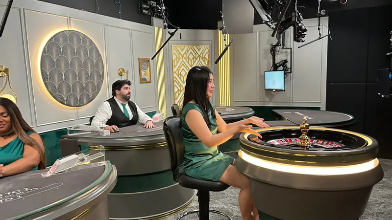 Professional dealer in casino studio dealing cards with multiple HD cameras filming