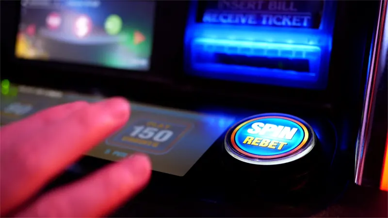Player's finger pressing the spin button on a slot machine interface